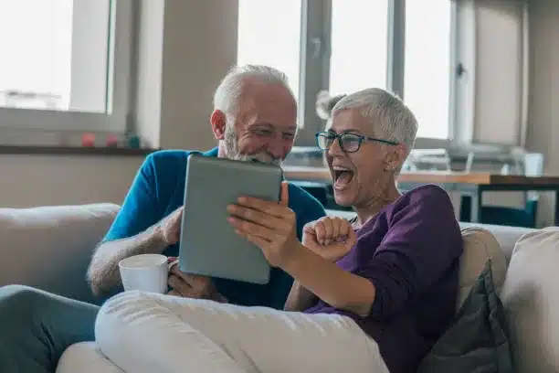 Smiling older people looking at tablet
